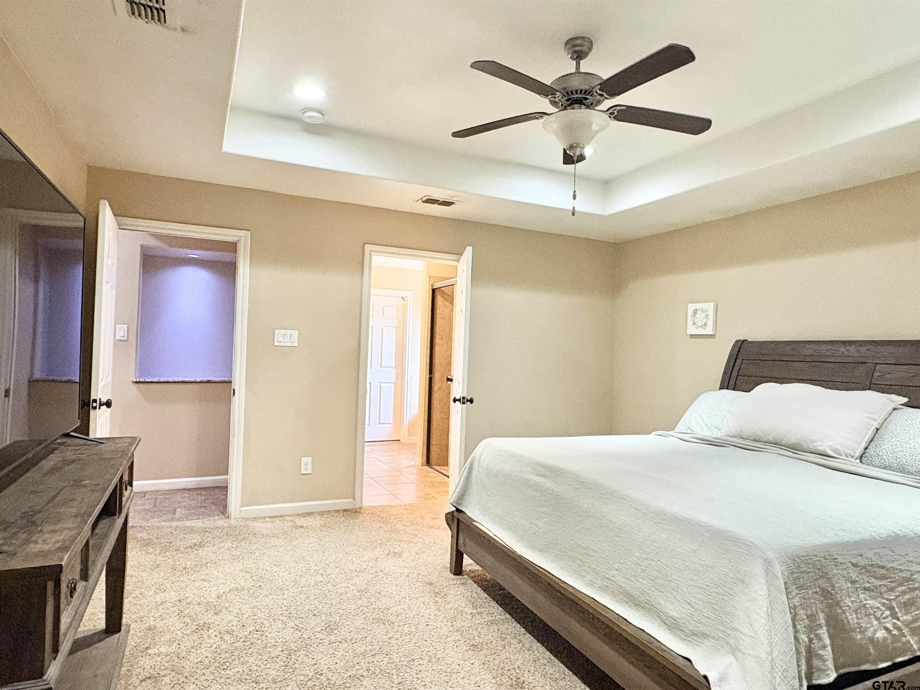28 County Road 3101 Pittsburg, TX 75686 - Photo 11 of 39 a bedroom with a bed and a chandelier
