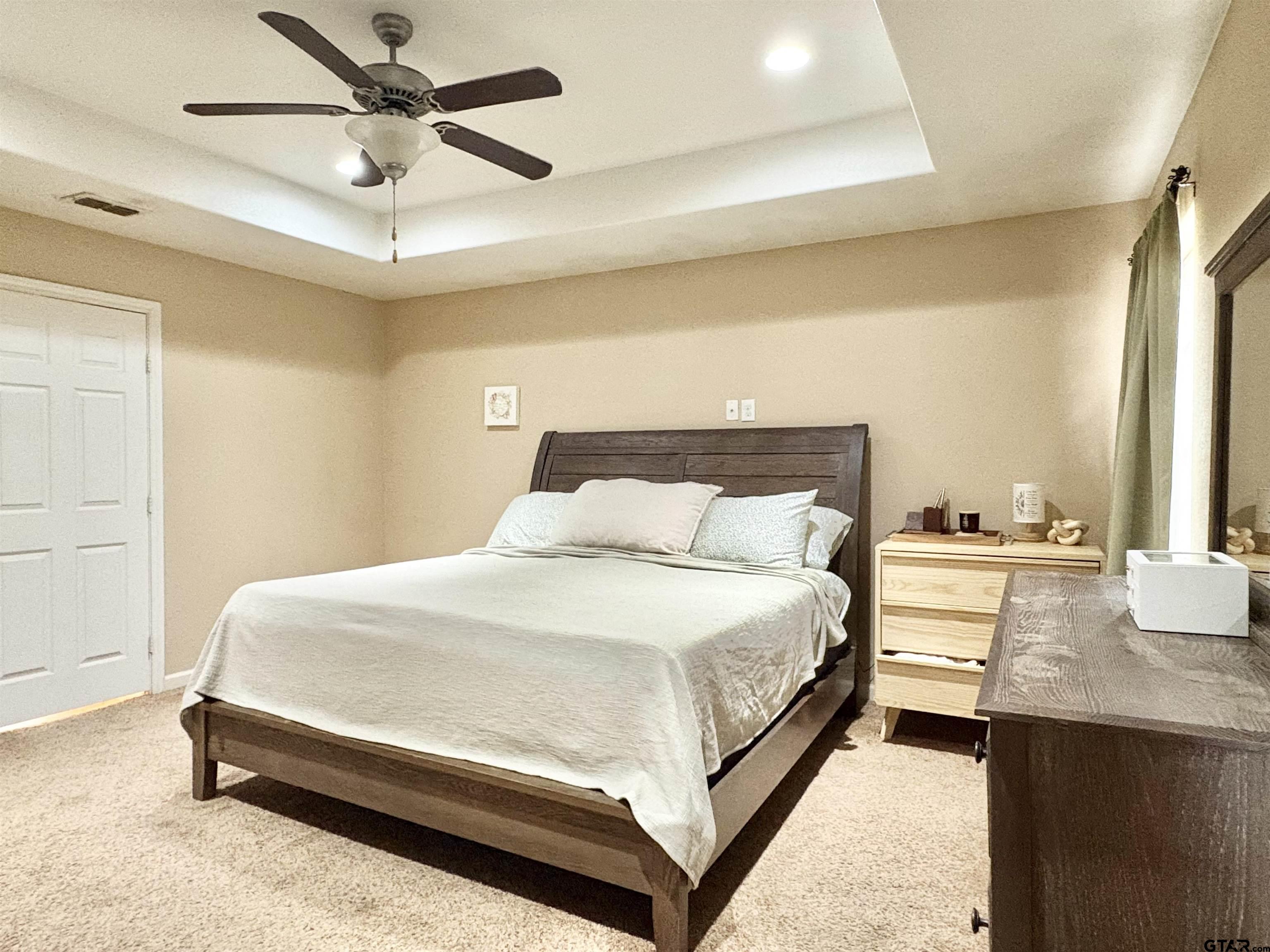 28 County Road 3101 Pittsburg, TX 75686 - Photo 12 of 39 a bedroom with a bed and a chandelier
