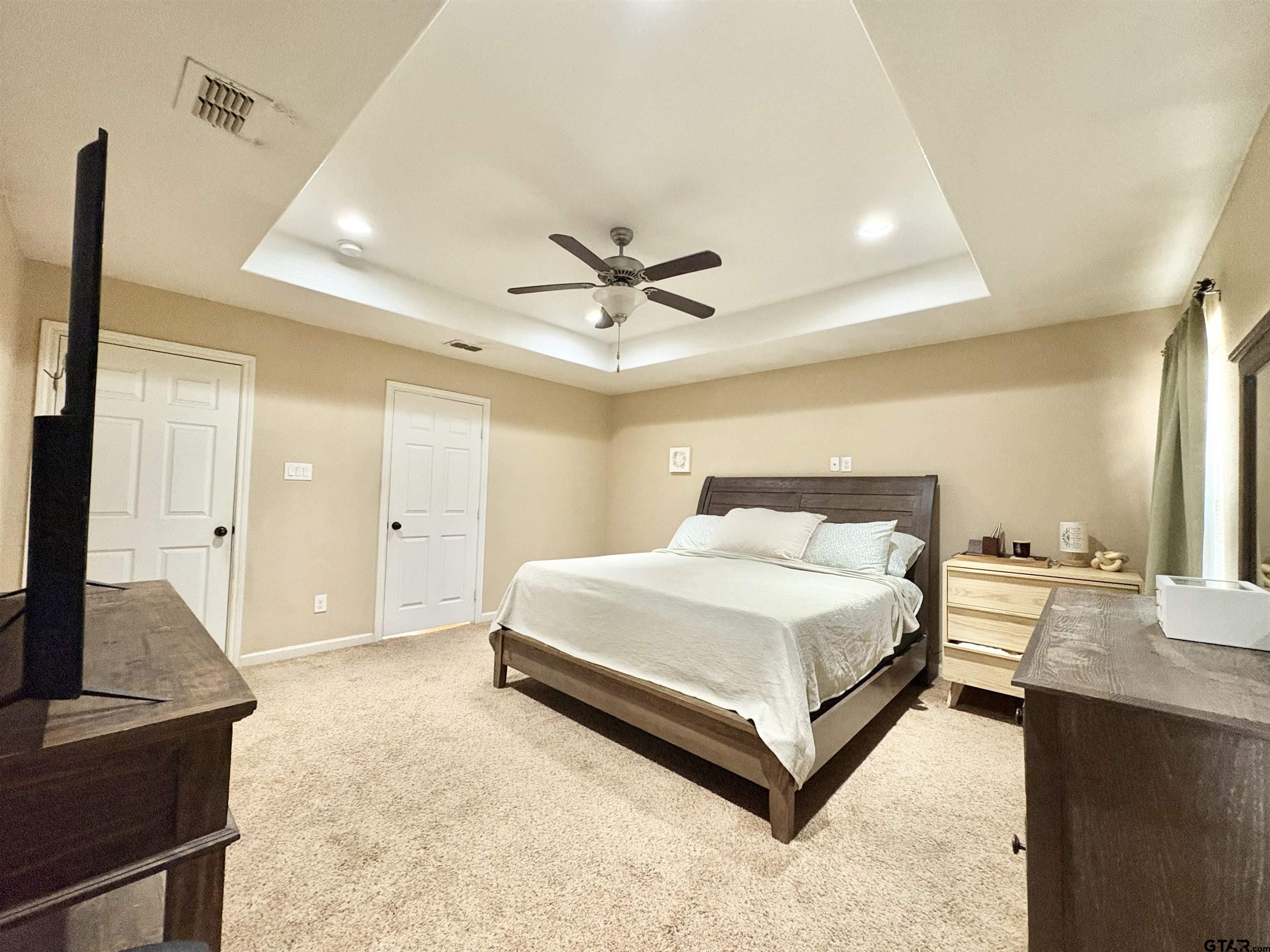 28 County Road 3101 Pittsburg, TX 75686 - Photo 14 of 39 a spacious bedroom with a bed and dresser with wooden floor