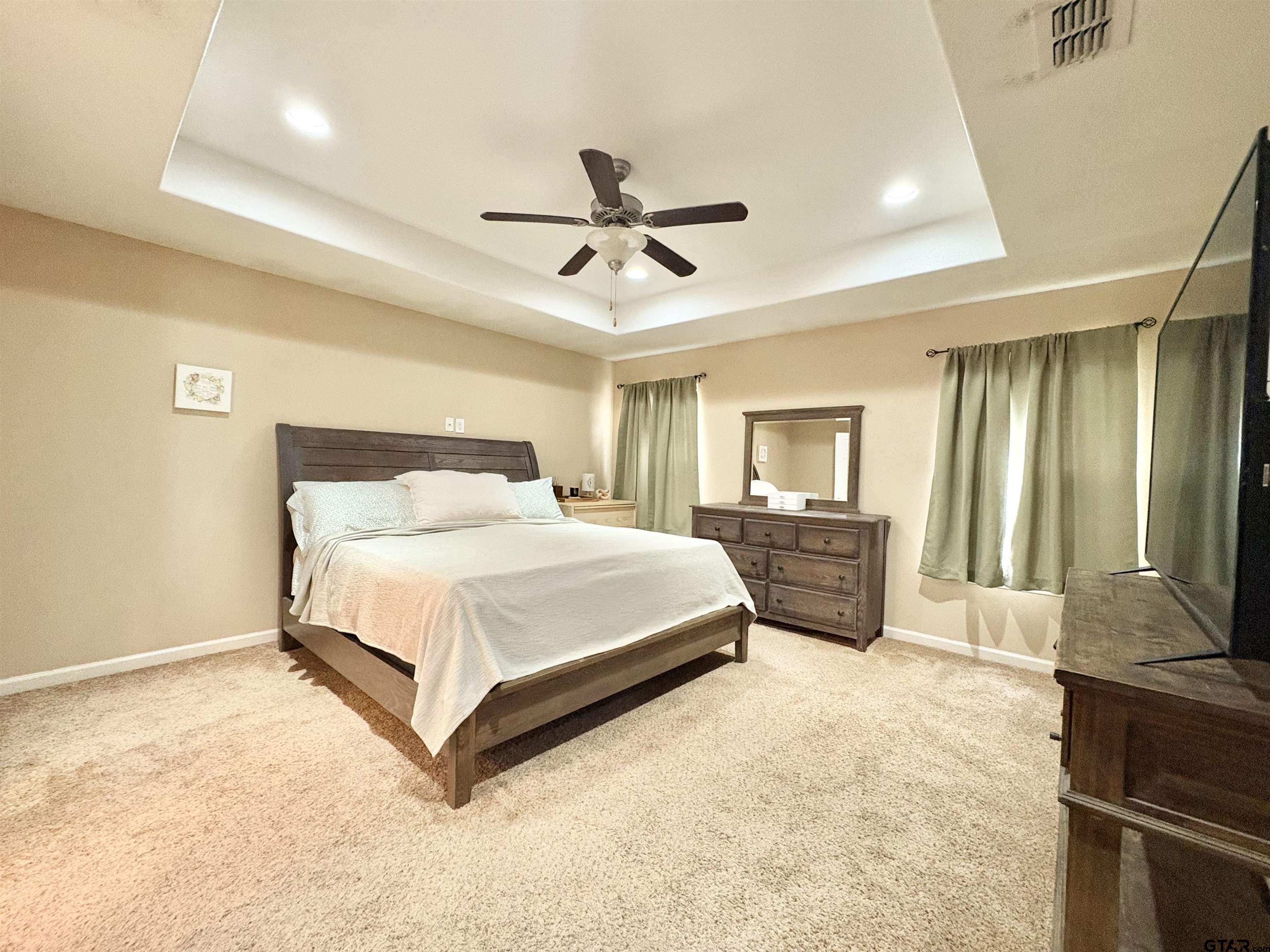 28 County Road 3101 Pittsburg, TX 75686 - Photo 15 of 39 a spacious bedroom with a bed and a flat screen tv