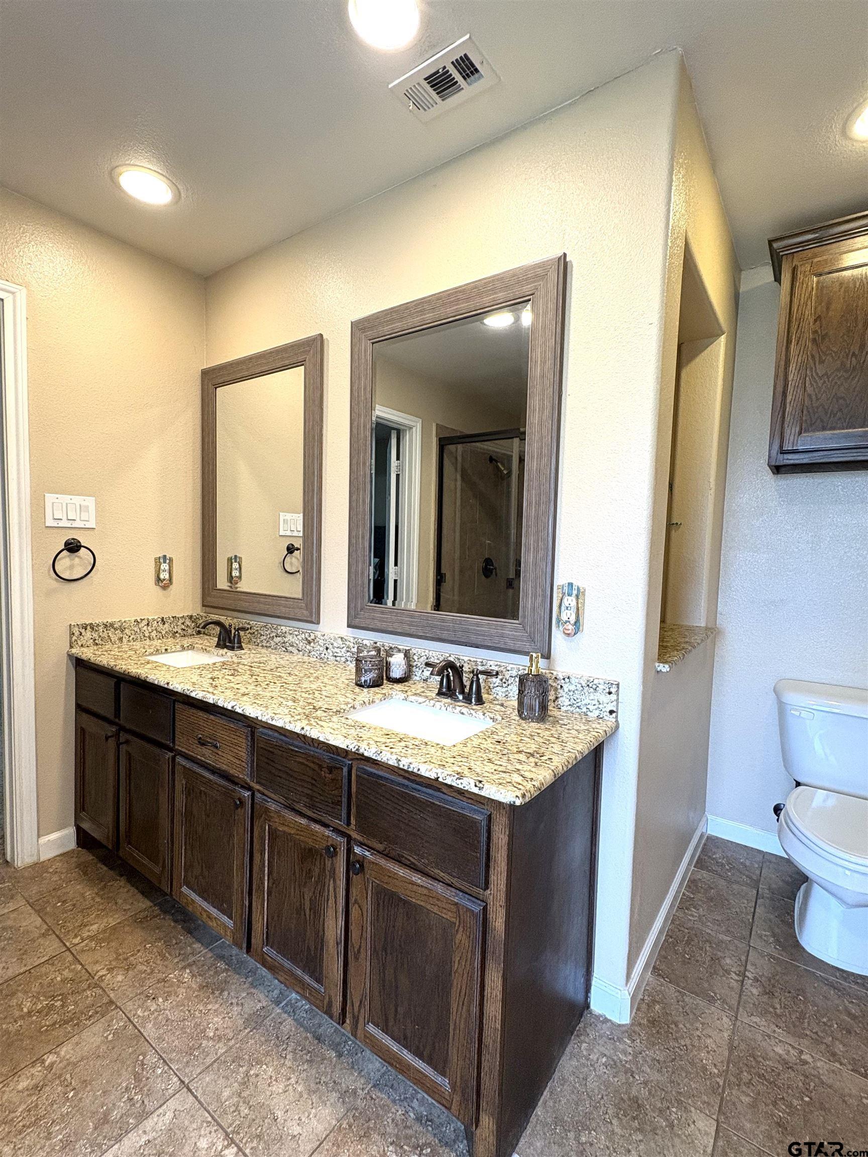 28 County Road 3101 Pittsburg, TX 75686 - Photo 16 of 39 a spacious bathroom with a granite countertop sink and a mirror