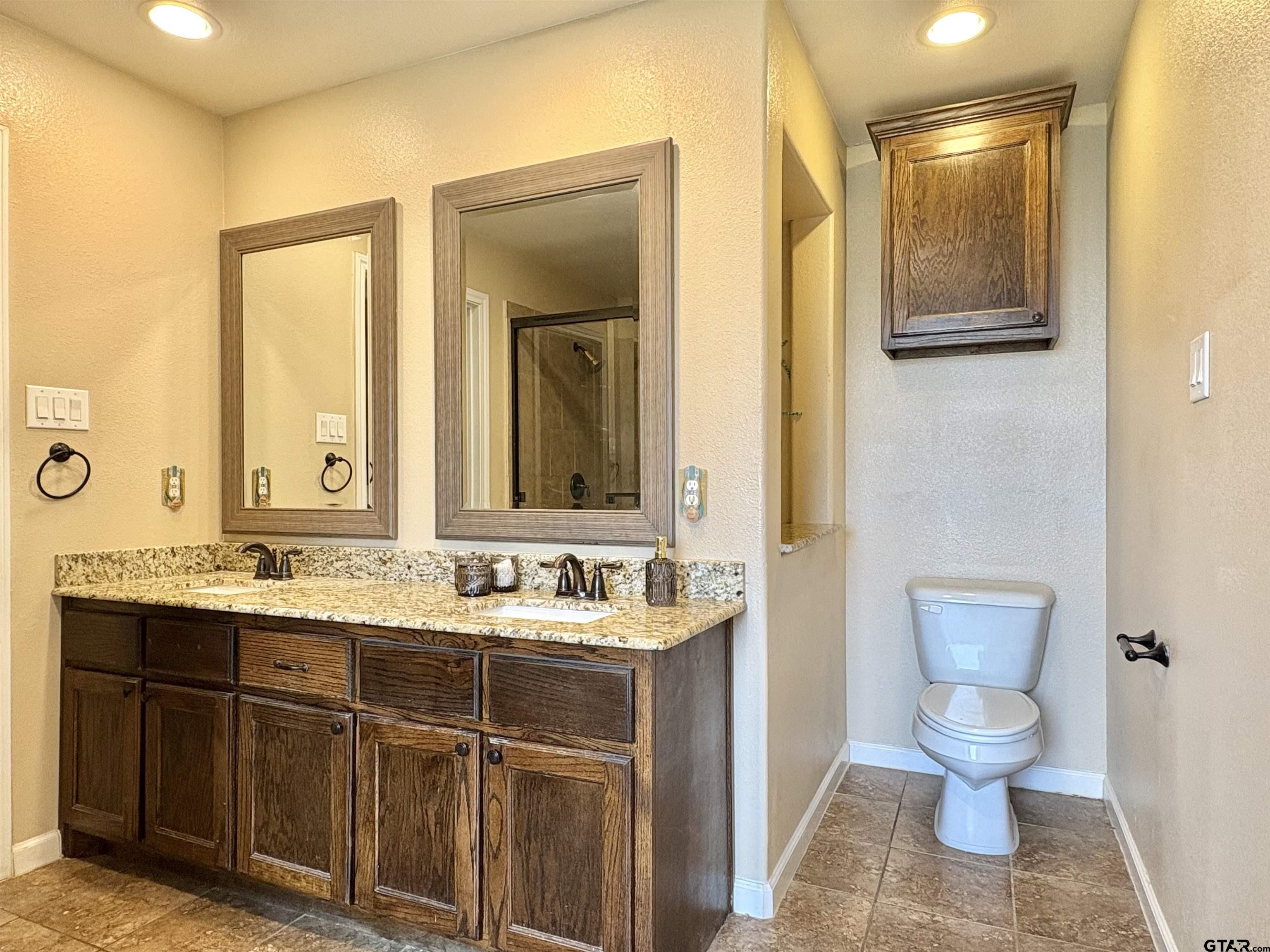 28 County Road 3101 Pittsburg, TX 75686 - Photo 20 of 39 a bathroom with a toilet sink and mirror