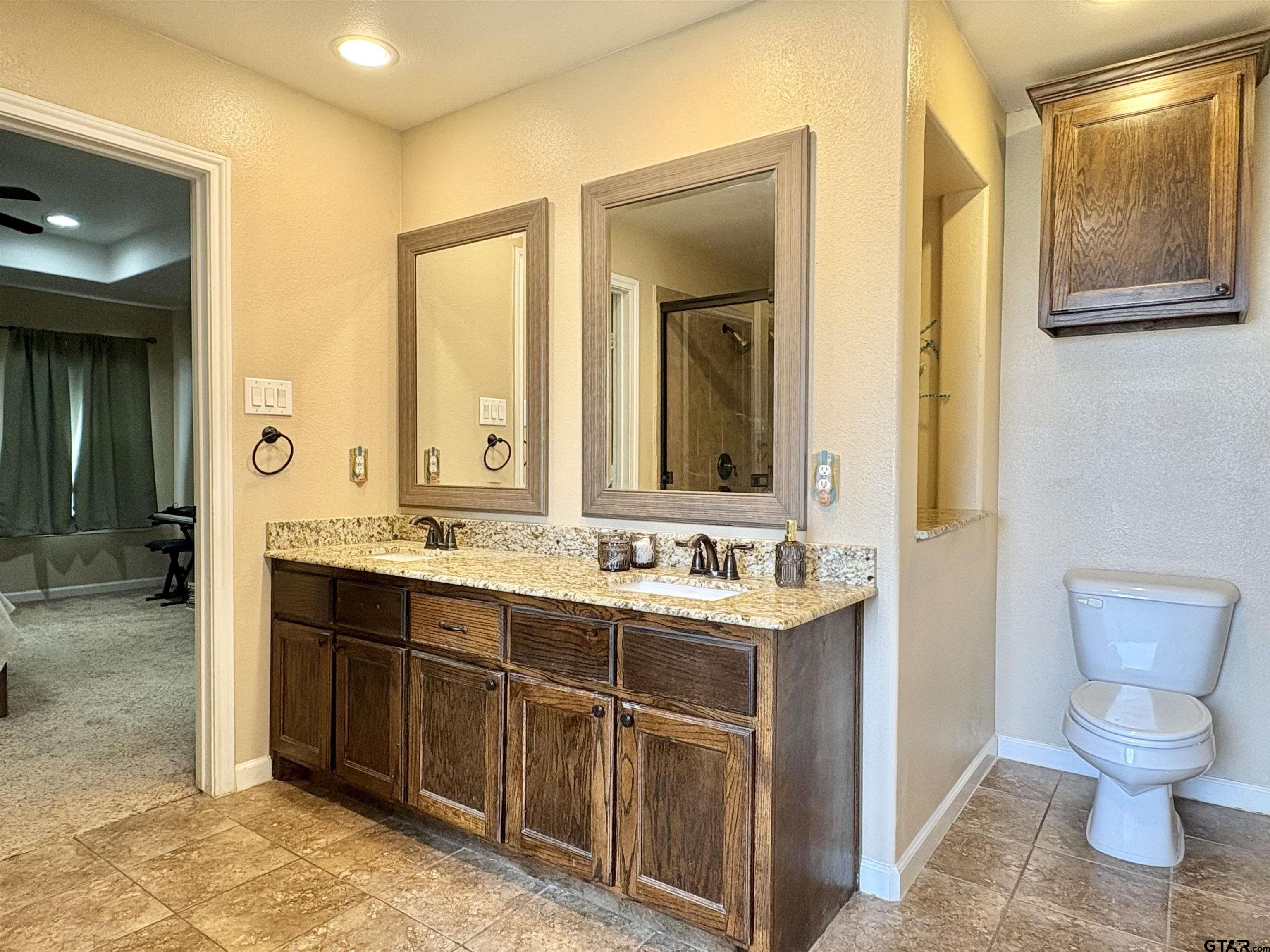 28 County Road 3101 Pittsburg, TX 75686 - Photo 21 of 39 a bathroom with a toilet sink and mirror
