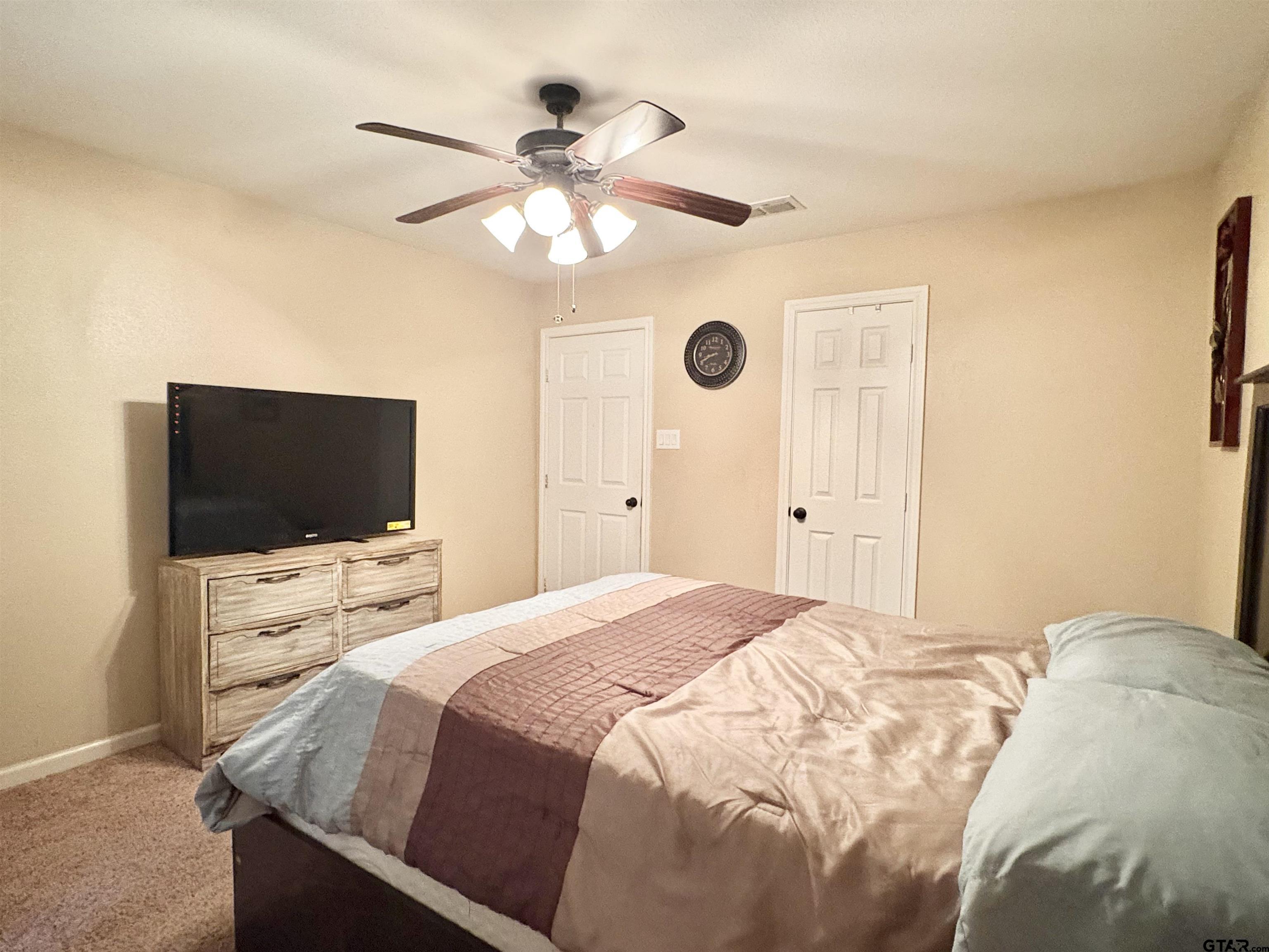 28 County Road 3101 Pittsburg, TX 75686 - Photo 22 of 39 a bedroom with a bed and a flat screen tv