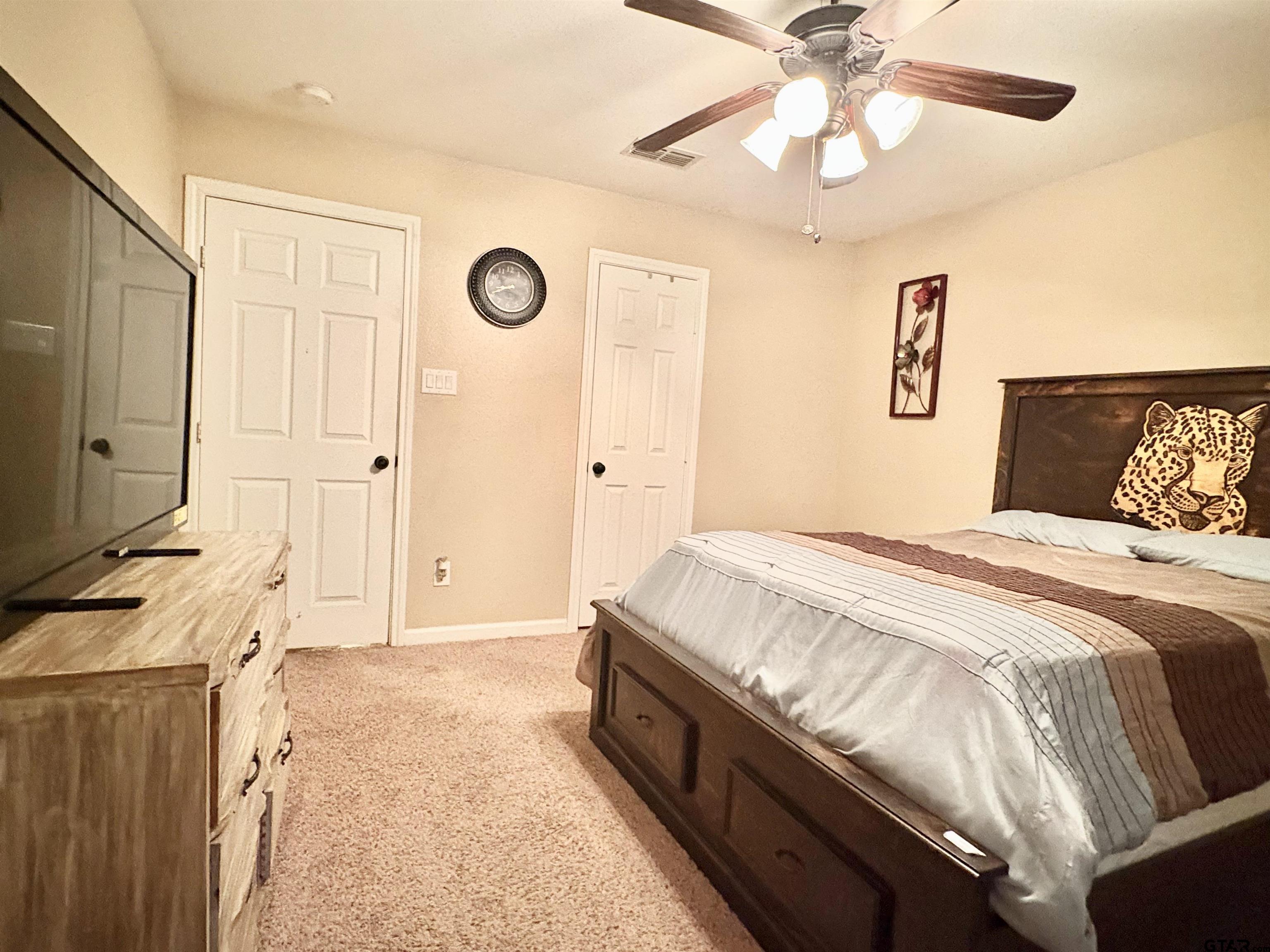 28 County Road 3101 Pittsburg, TX 75686 - Photo 23 of 39 a spacious bedroom with a bed and a chandelier