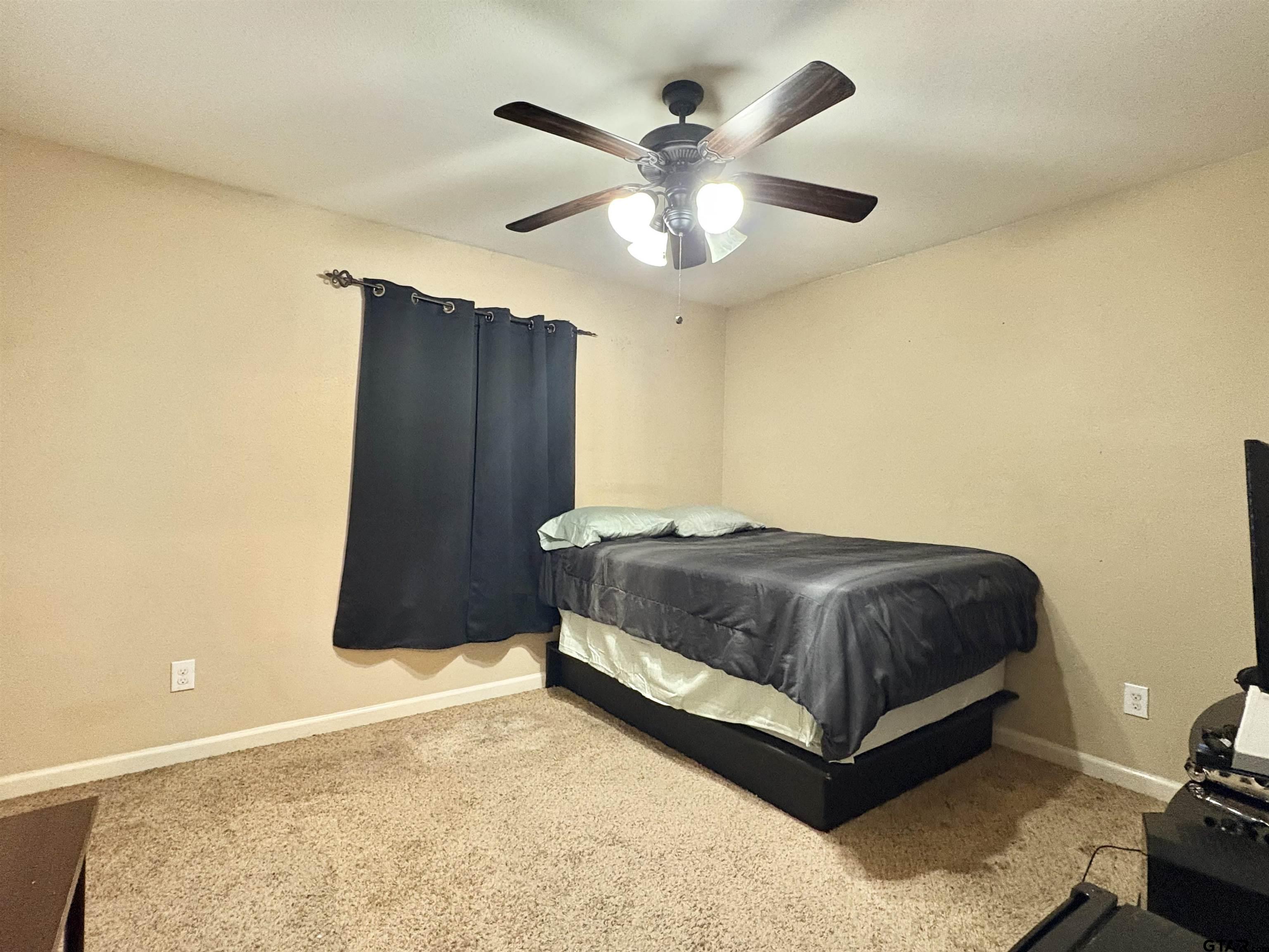 28 County Road 3101 Pittsburg, TX 75686 - Photo 24 of 39 a spacious bedroom with a bed and a ceiling fan