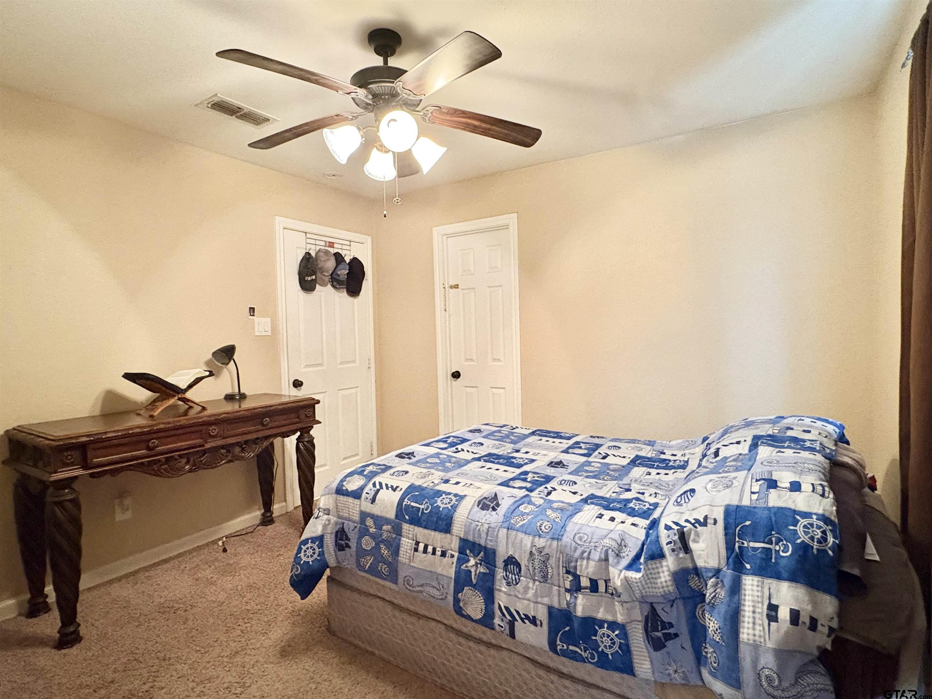 28 County Road 3101 Pittsburg, TX 75686 - Photo 28 of 39 a bedroom with a bed and a chandelier