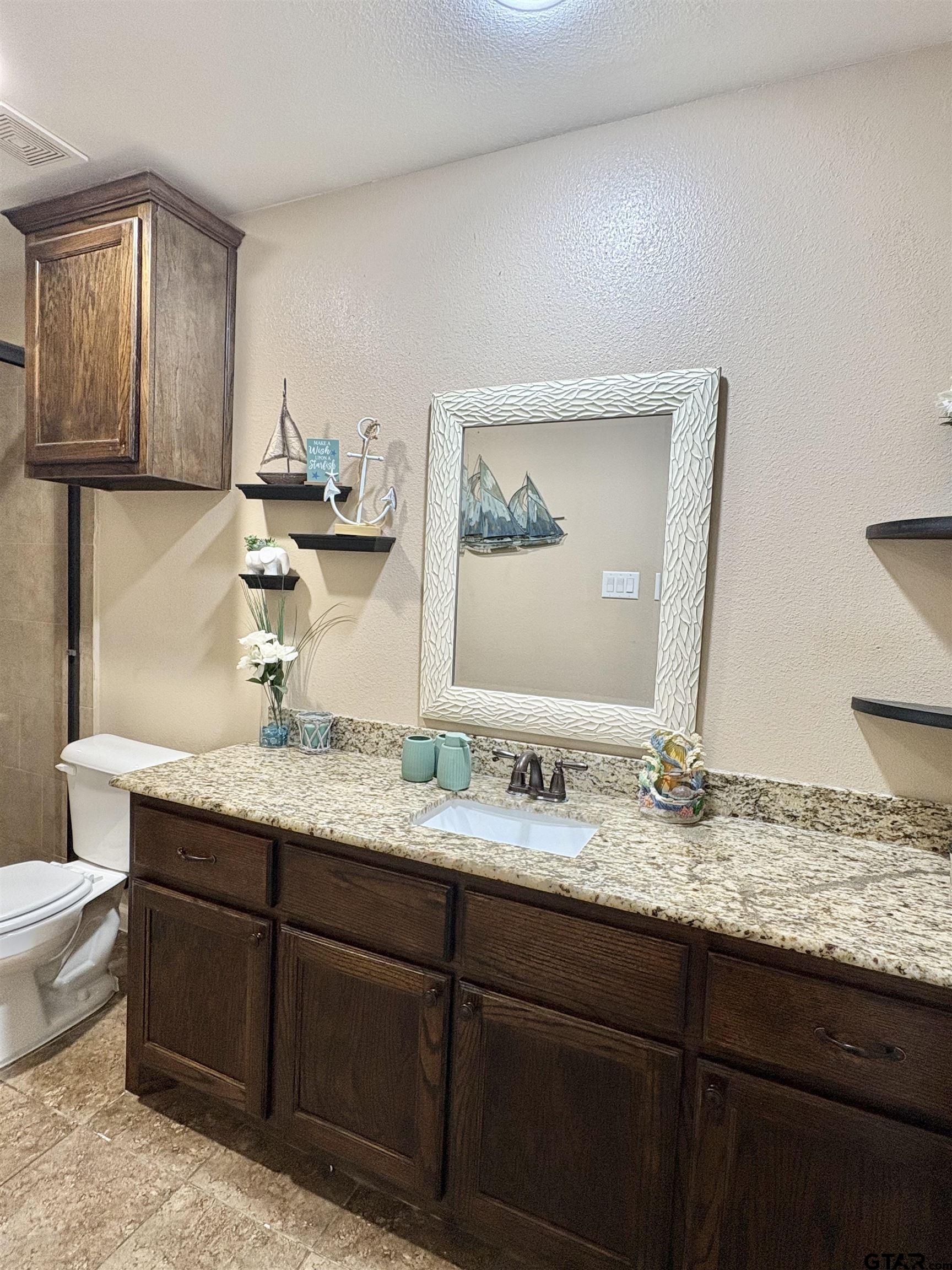 28 County Road 3101 Pittsburg, TX 75686 - Photo 30 of 39 a bathroom with a granite countertop sink and a mirror