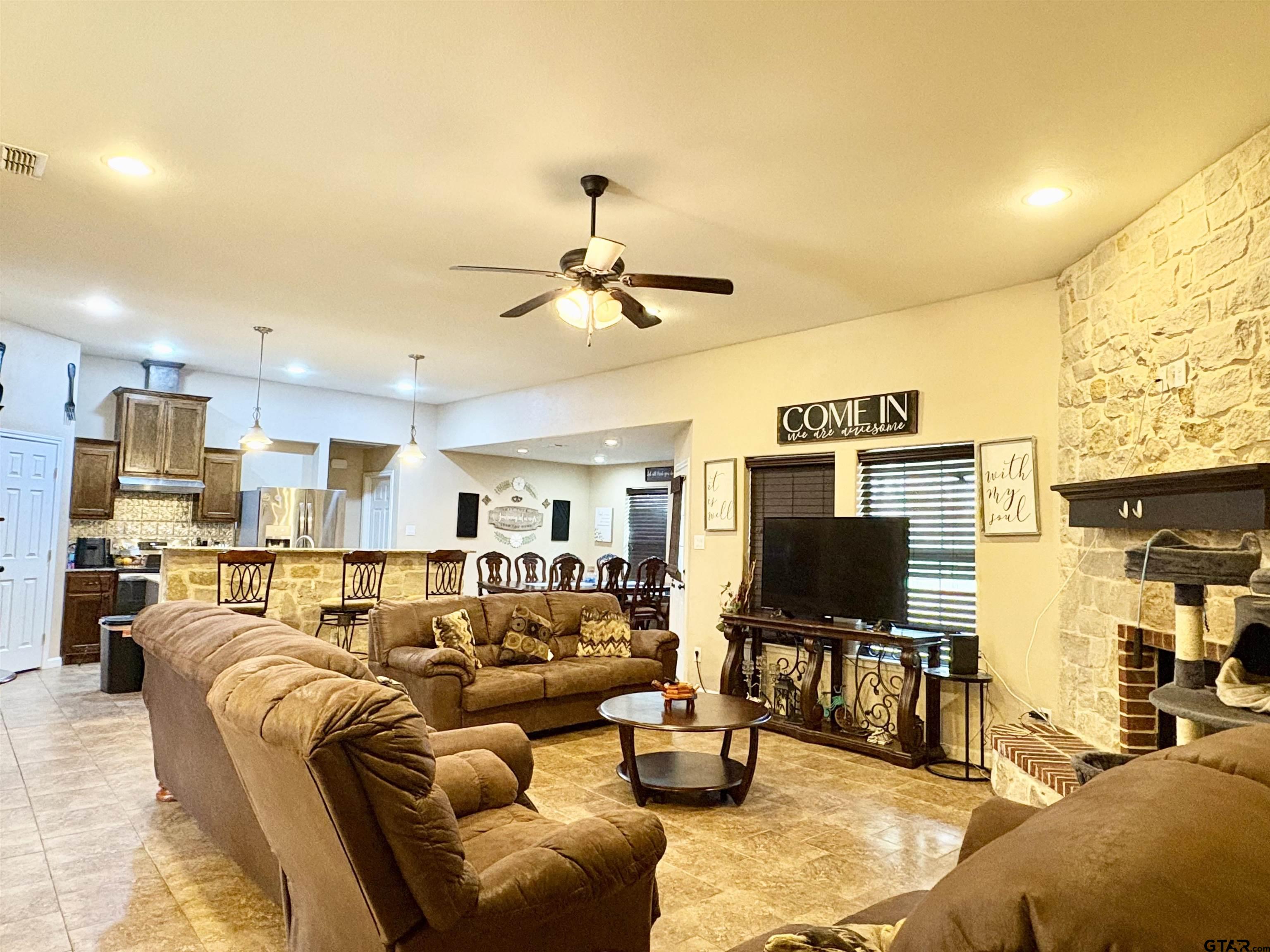 28 County Road 3101 Pittsburg, TX 75686 - Photo 3 of 39 a living room with furniture kitchen view and a flat screen tv