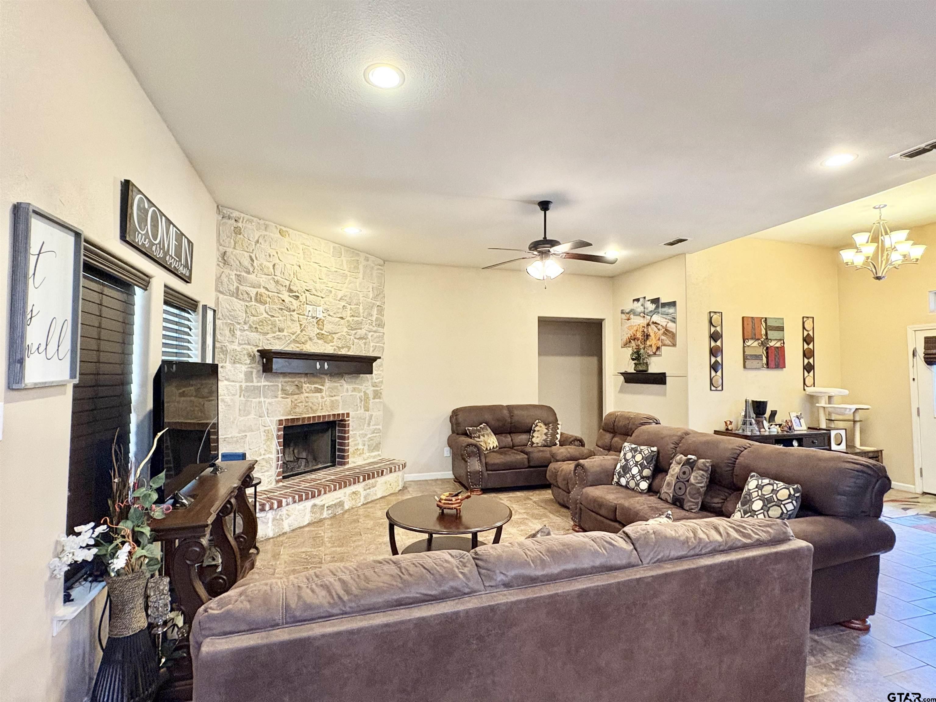 28 County Road 3101 Pittsburg, TX 75686 - Photo 4 of 39 a living room with furniture a fireplace and a flat screen tv