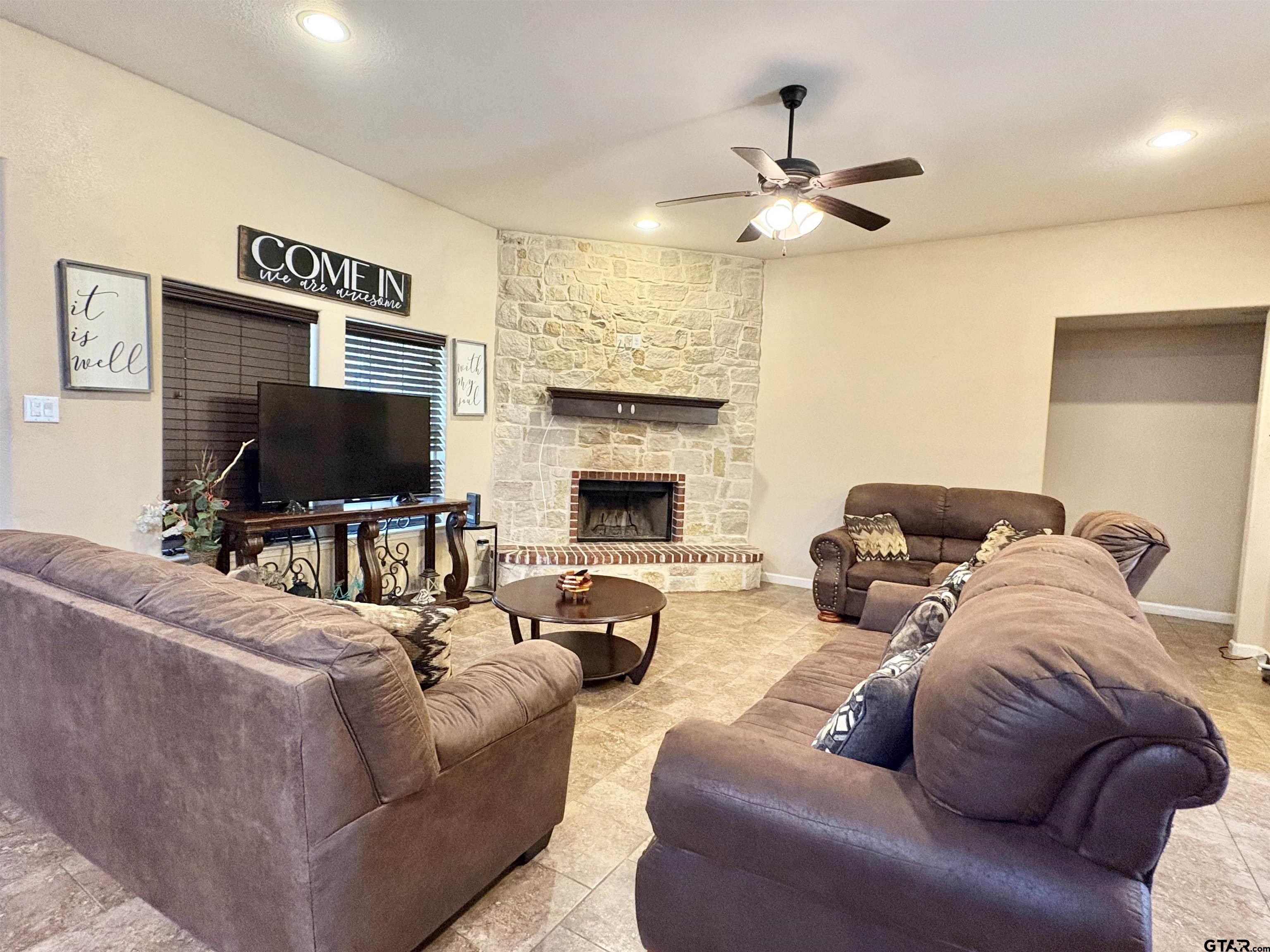 28 County Road 3101 Pittsburg, TX 75686 - Photo 5 of 39 a living room with furniture a fireplace and a flat screen tv
