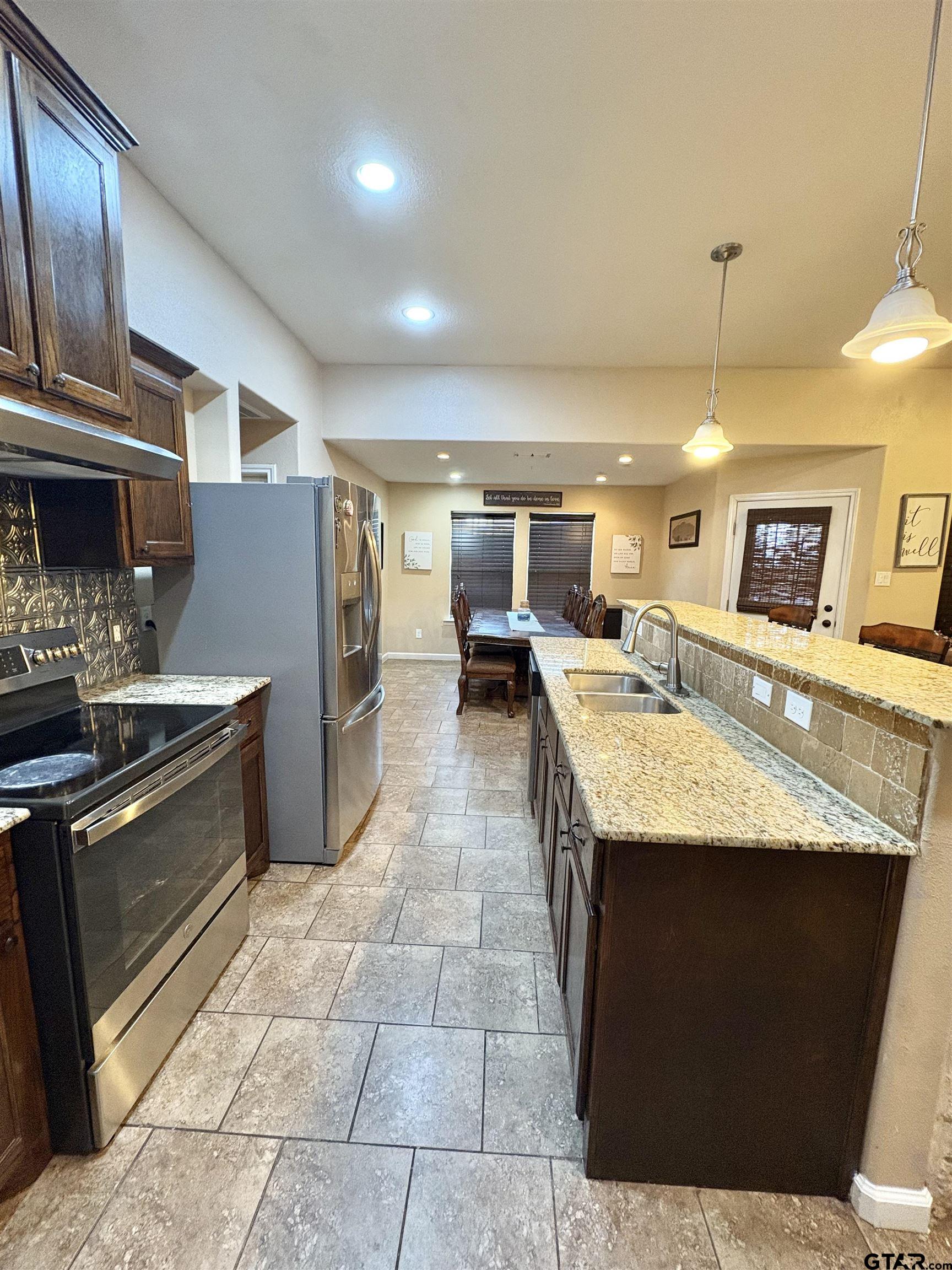 28 County Road 3101 Pittsburg, TX 75686 - Photo 10 of 39 a kitchen with granite countertop a stove and a refrigerator