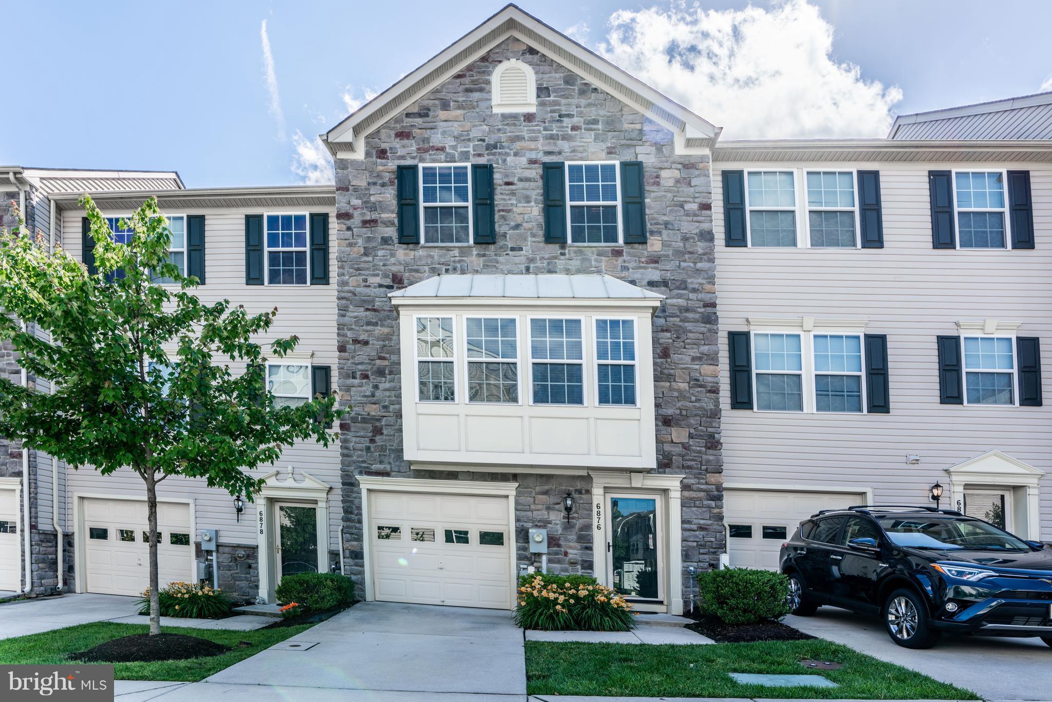 6876 Tasker Falls, Unit 77 Elkridge, MD 21075 - Photo 1 of 30 a front view of a house with a yard