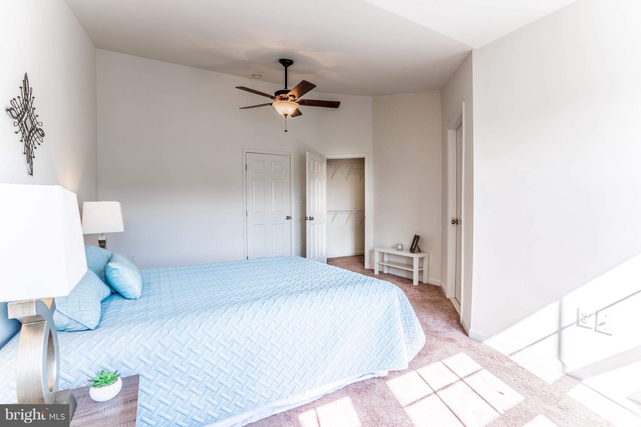 6876 Tasker Falls, Unit 77 Elkridge, MD 21075 - Photo 14 of 30 a bedroom with a bed and a chandelier