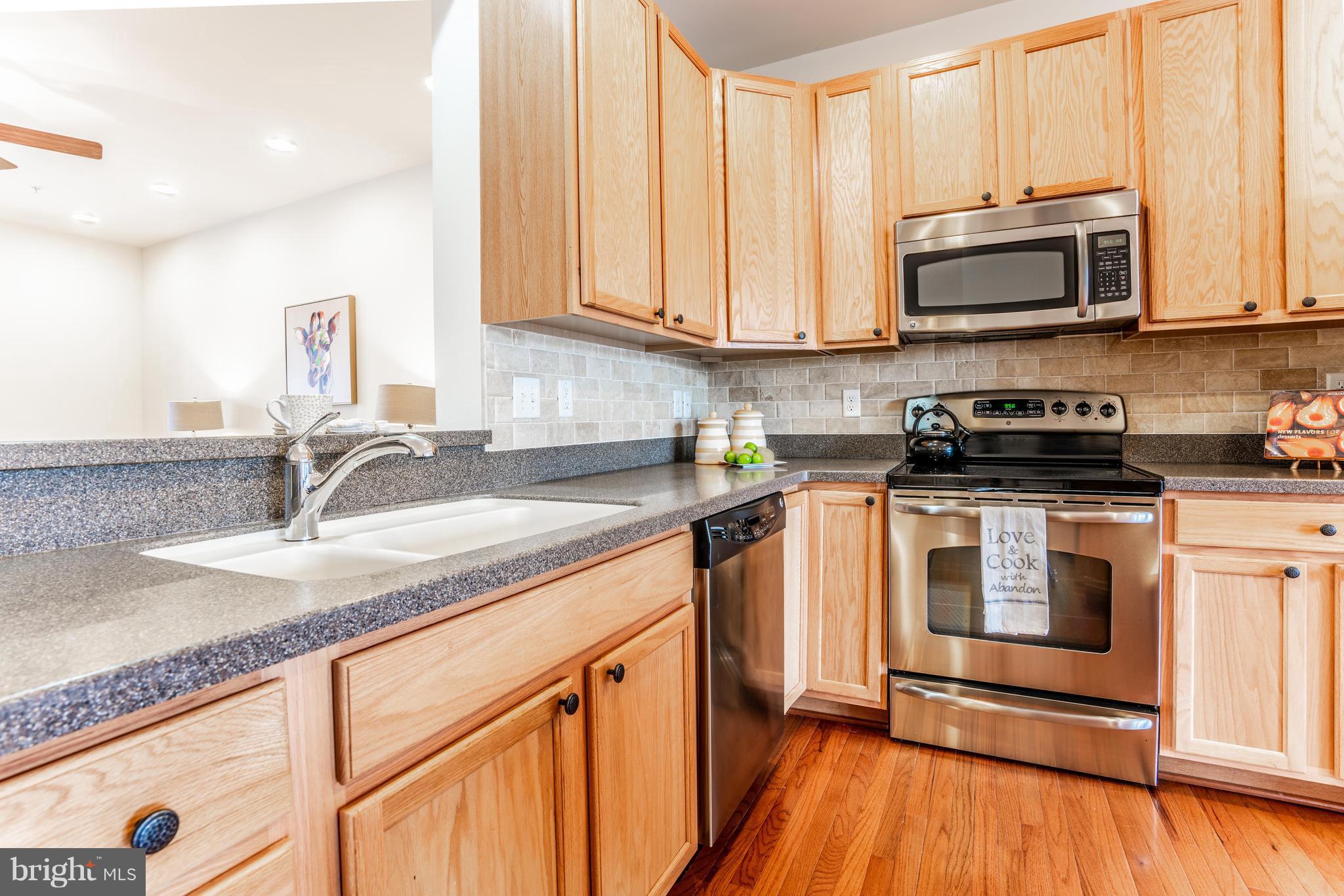 6876 Tasker Falls, Unit 77 Elkridge, MD 21075 - Photo 3 of 30 a kitchen with stainless steel appliances granite countertop a sink and a microwave