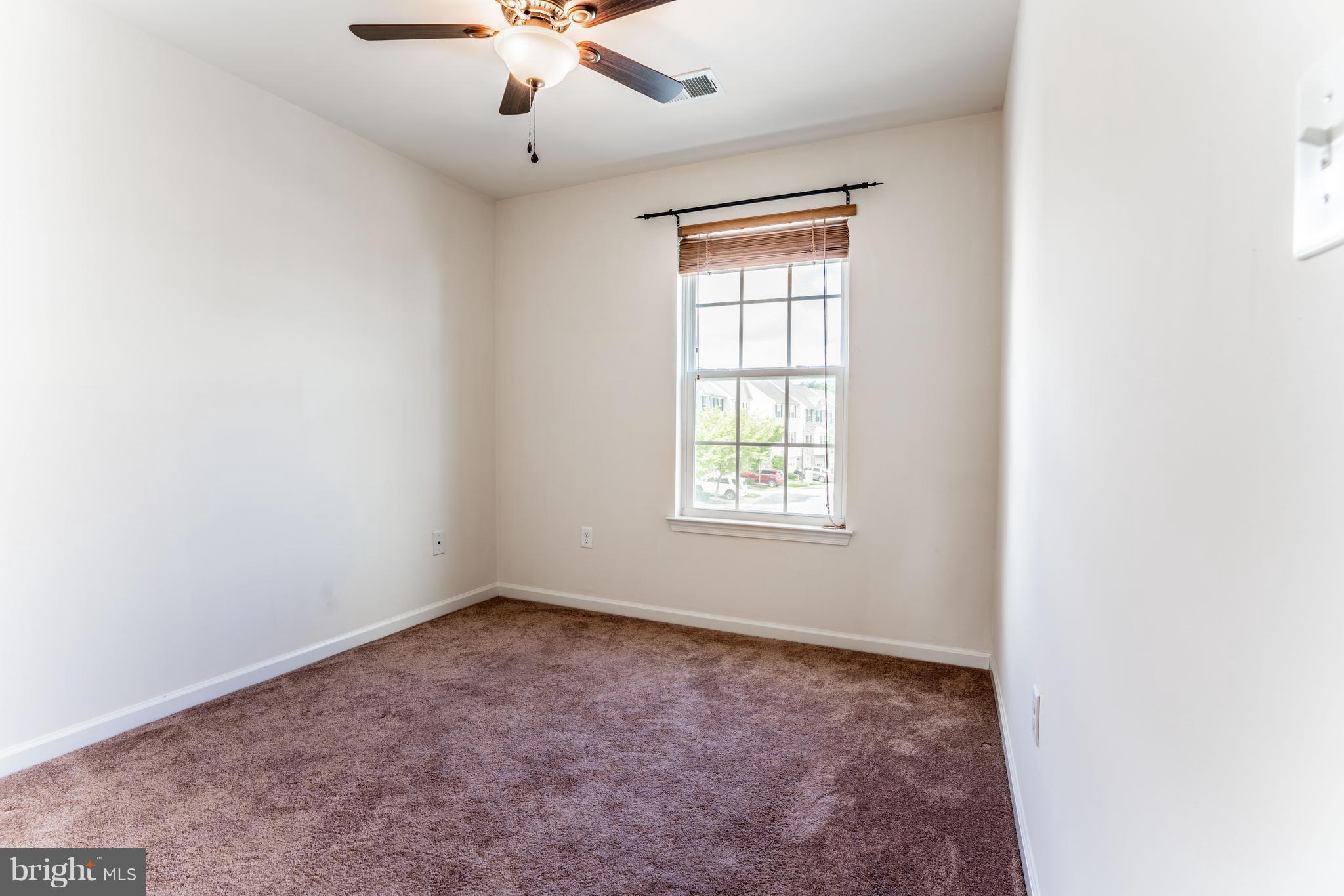 6876 Tasker Falls, Unit 77 Elkridge, MD 21075 - Photo 22 of 30 an empty room with a window and a ceiling fan