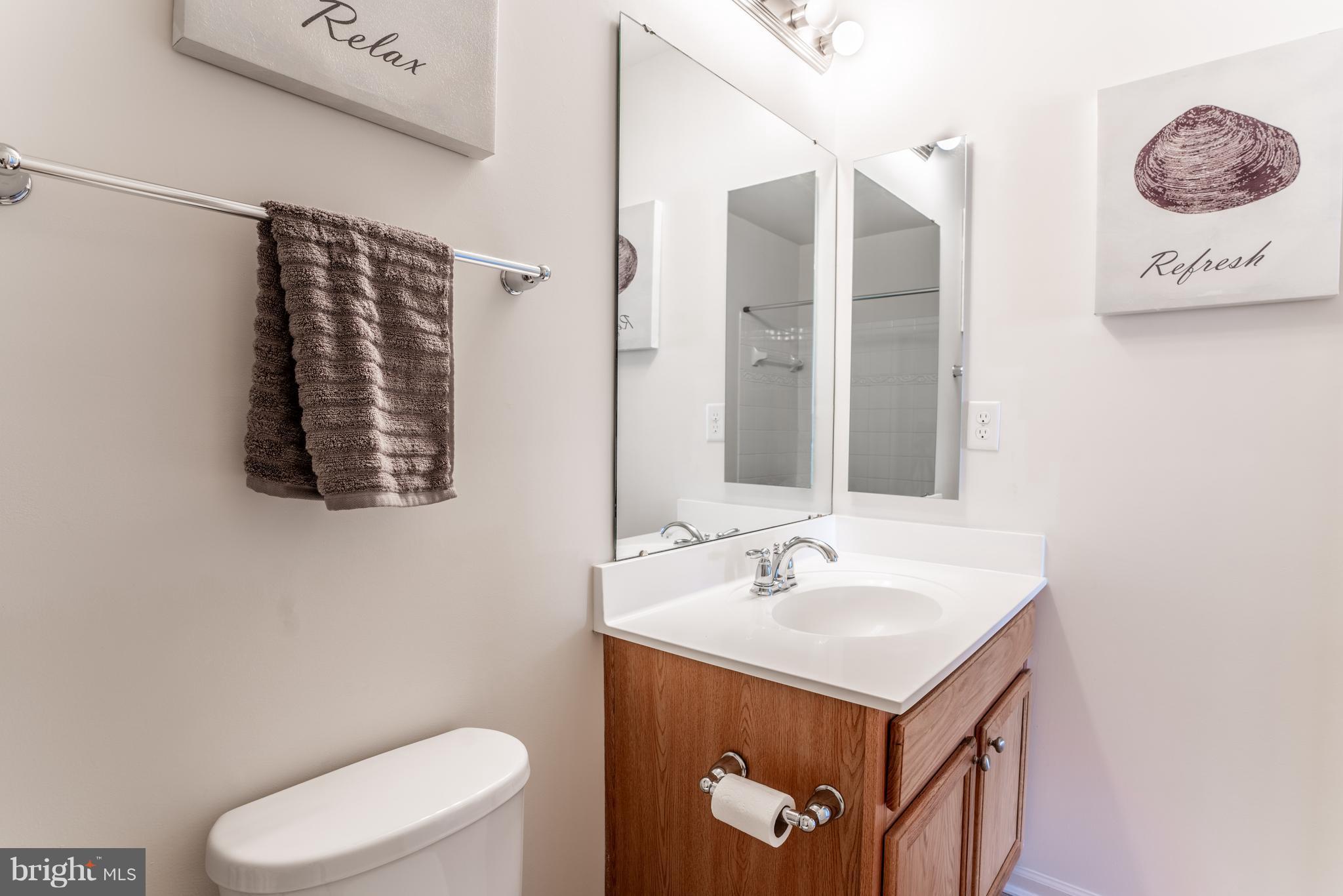 6876 Tasker Falls, Unit 77 Elkridge, MD 21075 - Photo 24 of 30 a bathroom with a sink mirror vanity and toilet