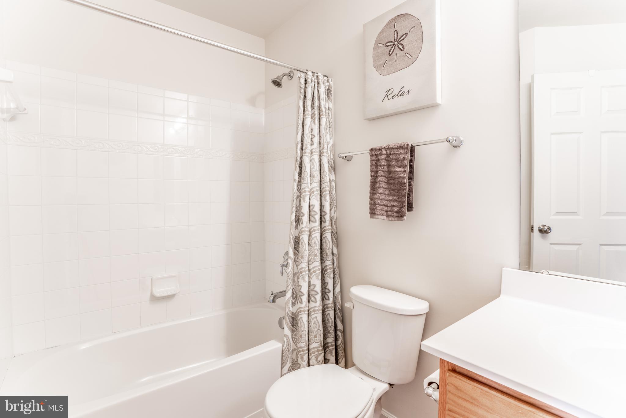 6876 Tasker Falls, Unit 77 Elkridge, MD 21075 - Photo 25 of 30 a white toilet sitting next to a bath tub