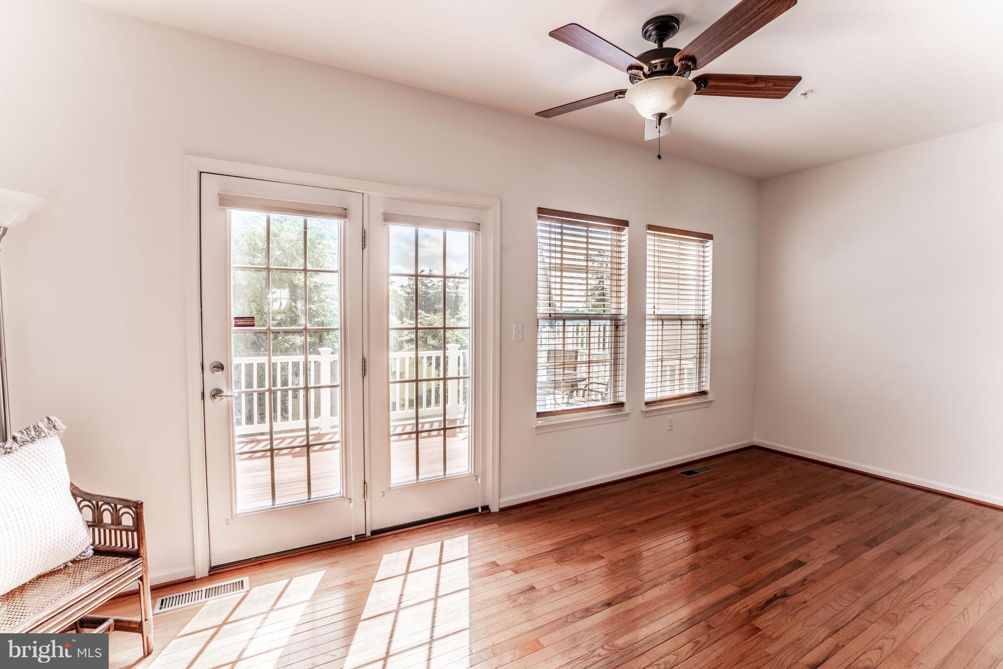 6876 Tasker Falls, Unit 77 Elkridge, MD 21075 - Photo 9 of 30 a view of an empty room with a window and wooden floor