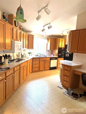 a kitchen with stainless steel appliances granite countertop a stove sink and cabinets