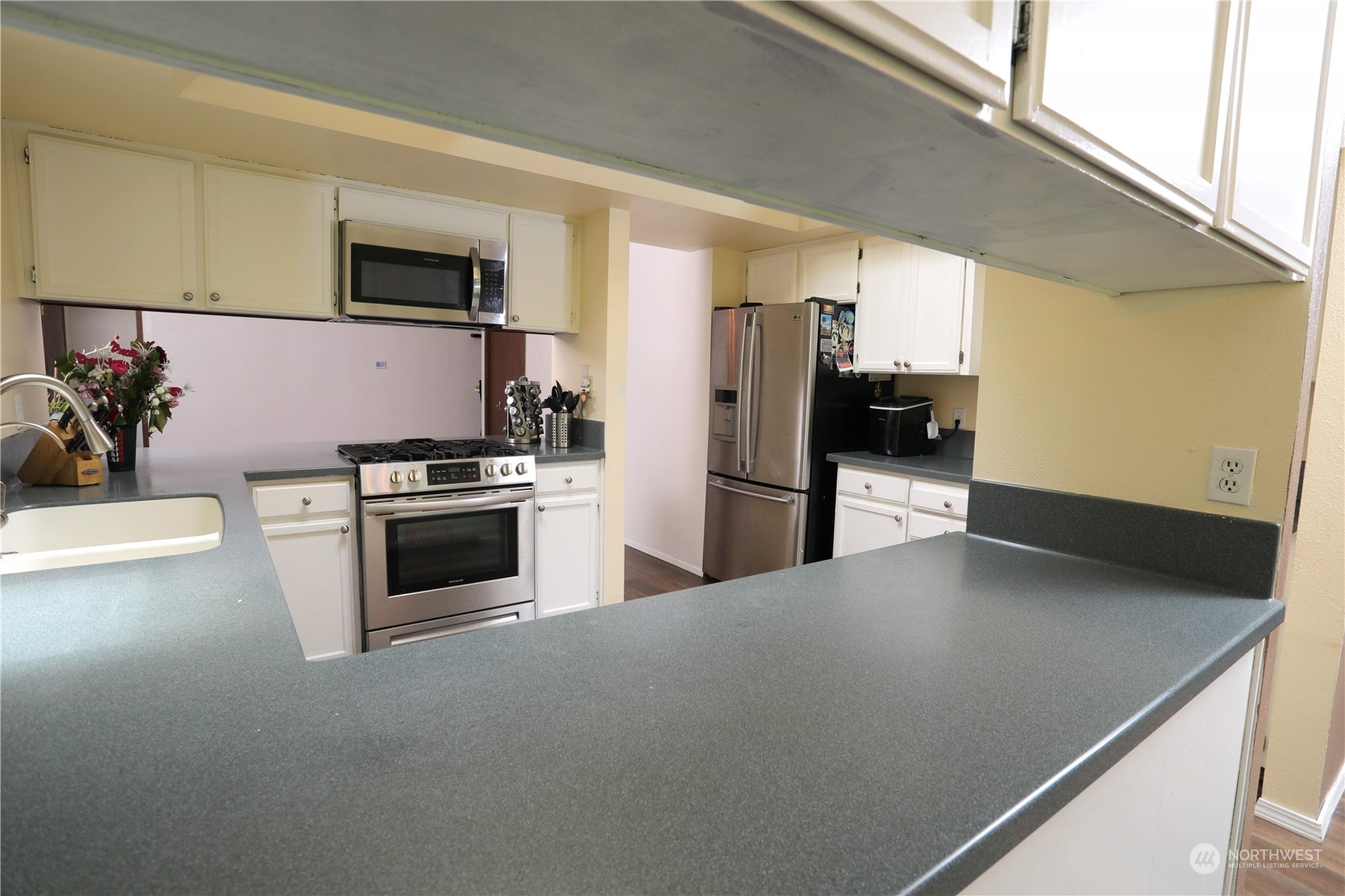 12503 Issaquah-Hobart Road Southeast Issaquah, WA 98027 - Photo 17 of 39 a kitchen with stainless steel appliances a refrigerator a stove a microwave a sink and white cabinets