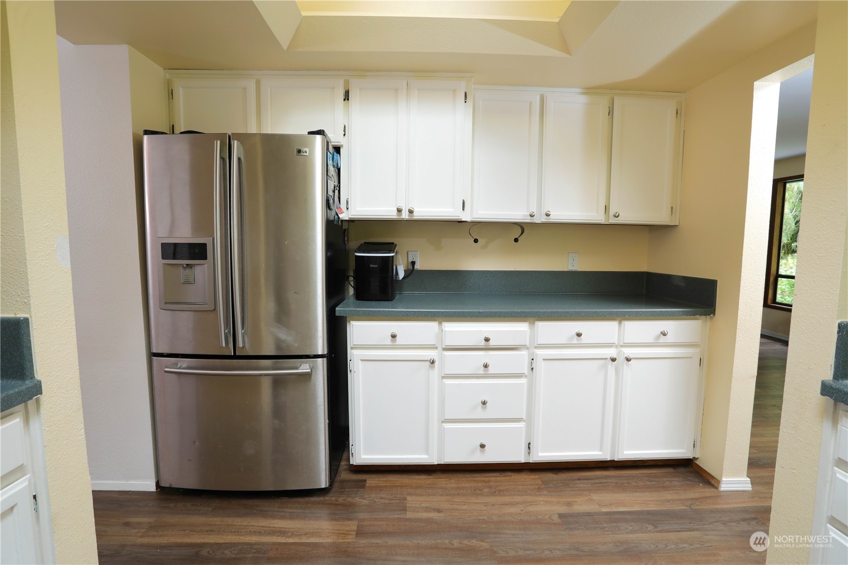 12503 Issaquah-Hobart Road Southeast Issaquah, WA 98027 - Photo 18 of 39 a kitchen with white cabinets white stainless steel appliances and wooden floors