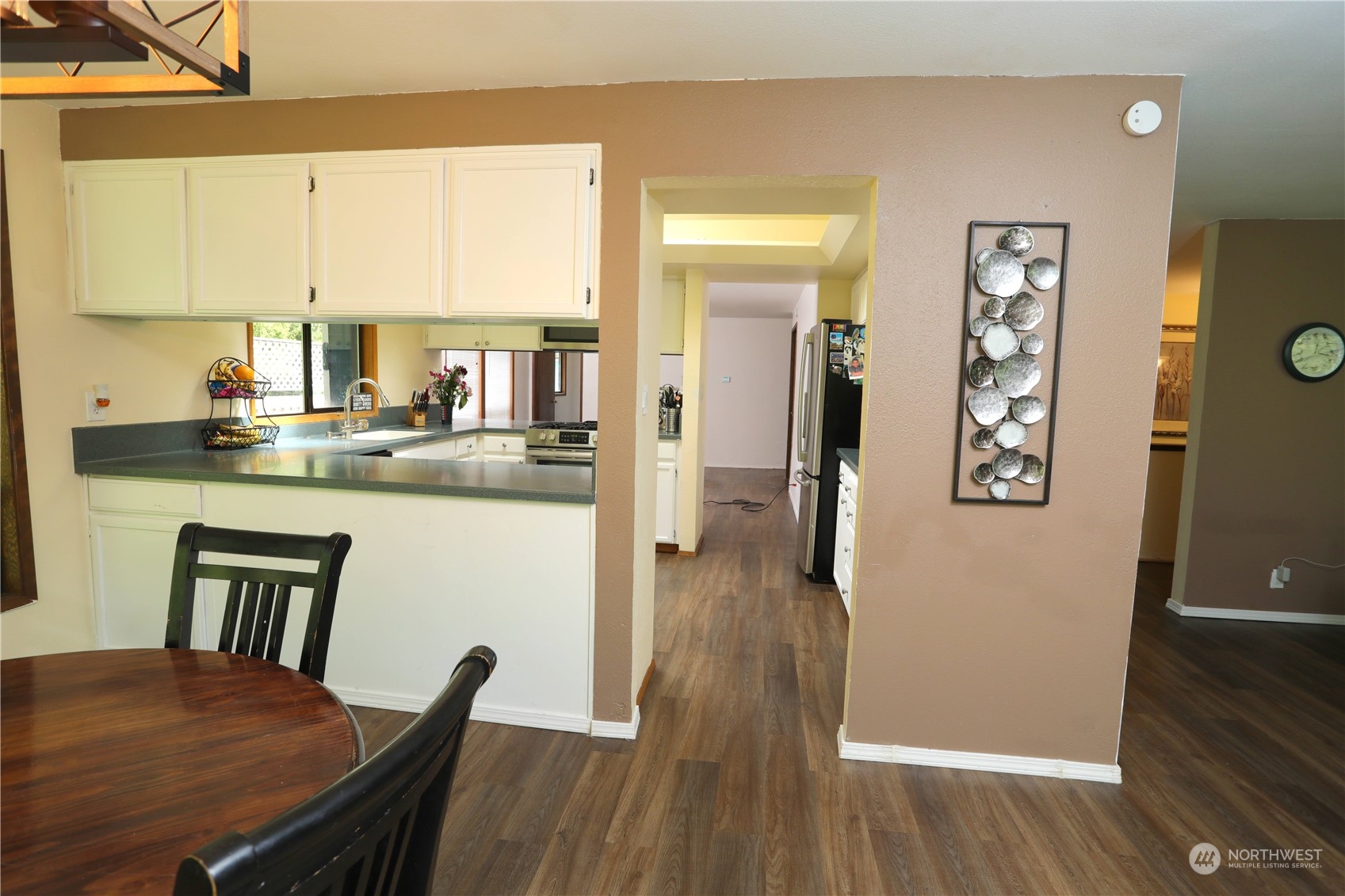12503 Issaquah-Hobart Road Southeast Issaquah, WA 98027 - Photo 21 of 39 a kitchen with stainless steel appliances granite countertop a stove a refrigerator a dining table and chairs with wooden floor