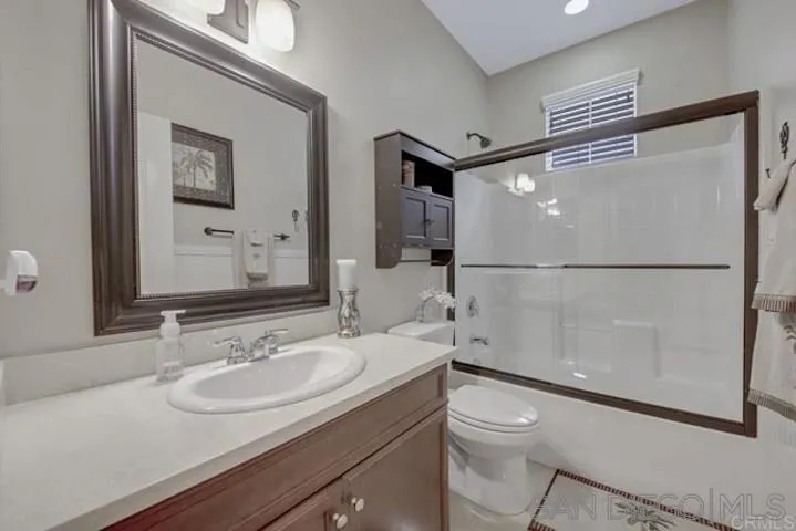 1535 Chert Drive San Marcos, CA 92078 - Photo 13 of 24 a bathroom with a granite countertop sink toilet a mirror and shower