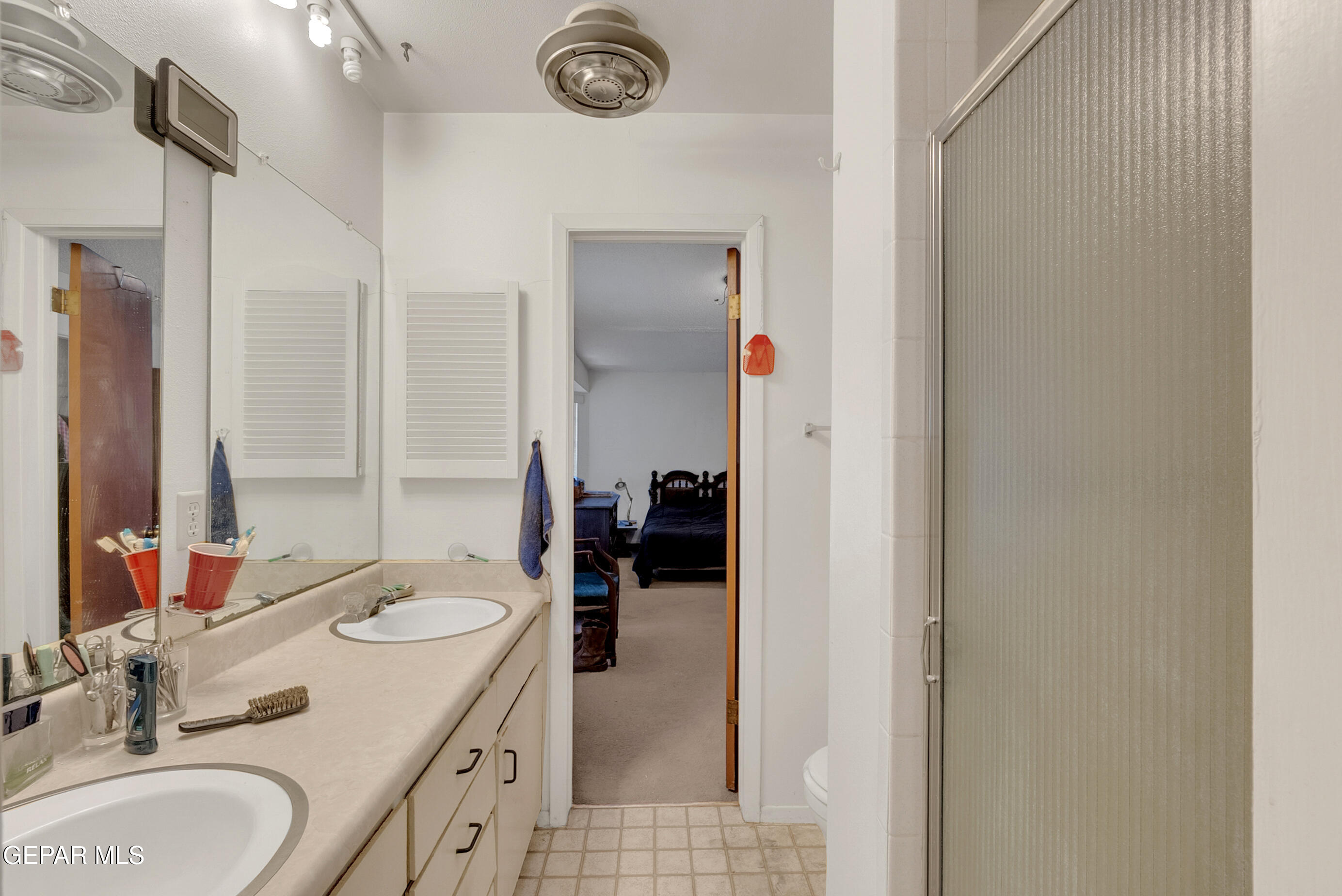299 Tranquility Road Canutillo, TX 79835 - Photo 29 of 55 a en suite bathroom with a granite countertop sink and a mirror