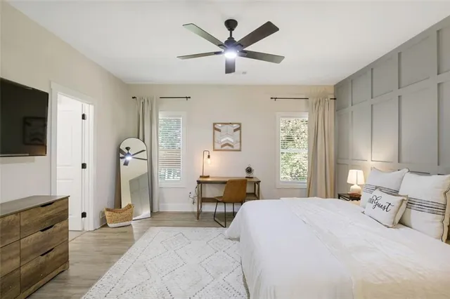 a bedroom with a bed a window and a flat screen tv