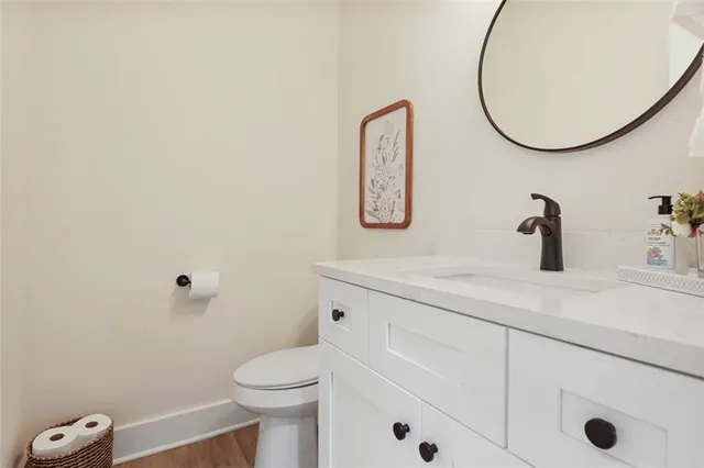 a bathroom with a toilet sink vanity and mirror