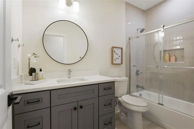 a bathroom with a toilet a sink a mirror and a shower