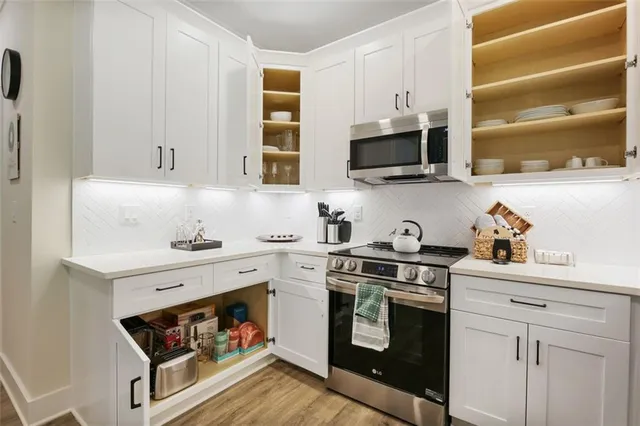 a kitchen with stainless steel appliances granite countertop a stove a sink and a microwave