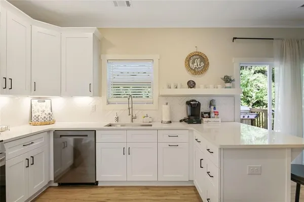 a kitchen with granite countertop white cabinets and white appliances