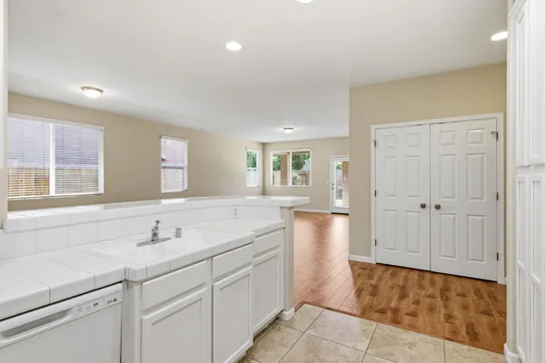 a kitchen with white cabinets and white appliances