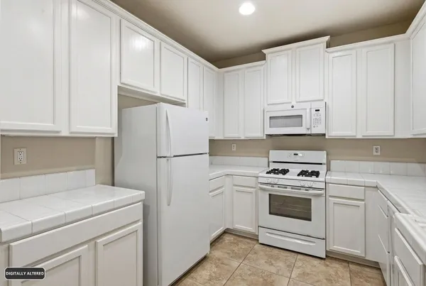 a kitchen with white cabinets and white appliances