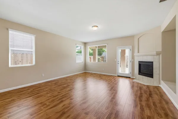 a view of a kitchen and an empty room with a fireplace