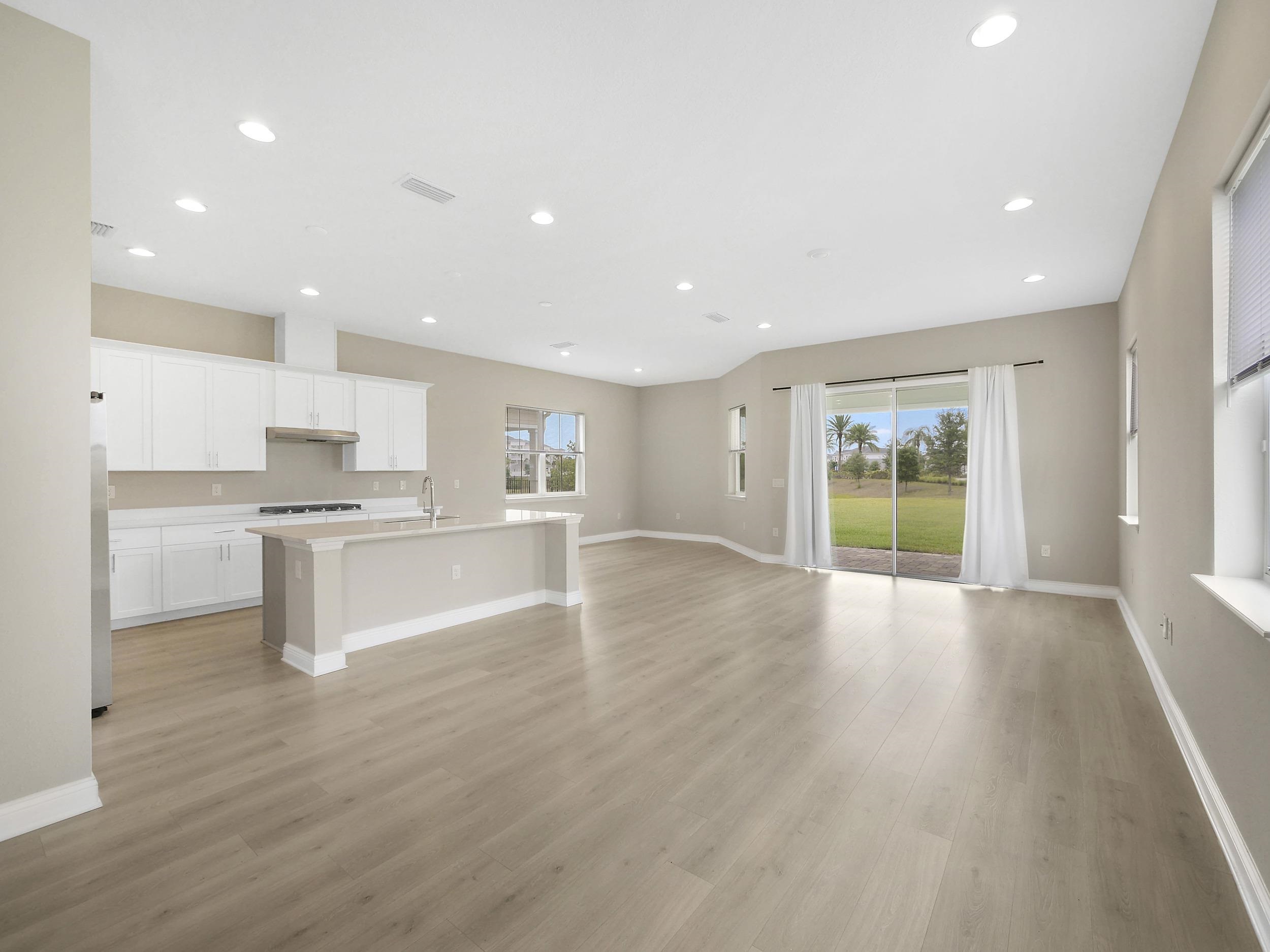 471 Rum Runner Way St. Johns, FL 32259 - Photo 10 of 42 a large kitchen with white cabinets and wooden floor