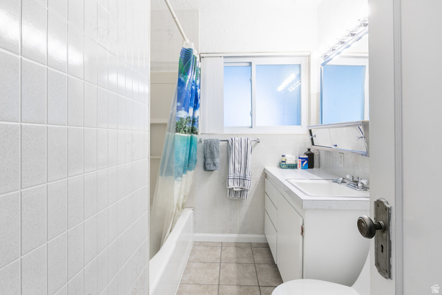 59 East Pinehurst Street Tooele, UT 84074 - Photo 14 of 22 Bathroom featuring a white subway tile shower surround, a built-in bathtub, a window with frosted panes, a single vanity with storage, and a mirrored medicine cabinet