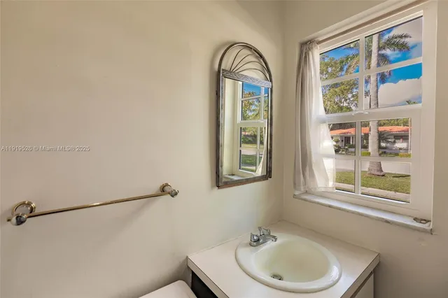 an empty room with wooden floor ceiling fan and windows