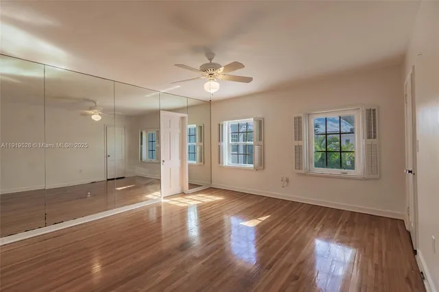 a view of a room with wooden floor and a ceiling fan