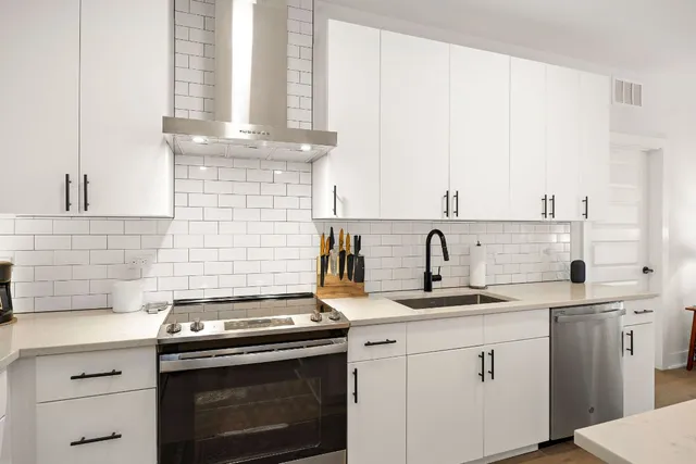 a kitchen with granite countertop a sink stainless steel appliances and cabinets