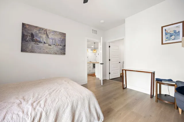 a bedroom with a bed and a painting on the wall