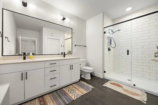 a spacious bathroom with a double vanity sink toilet and shower