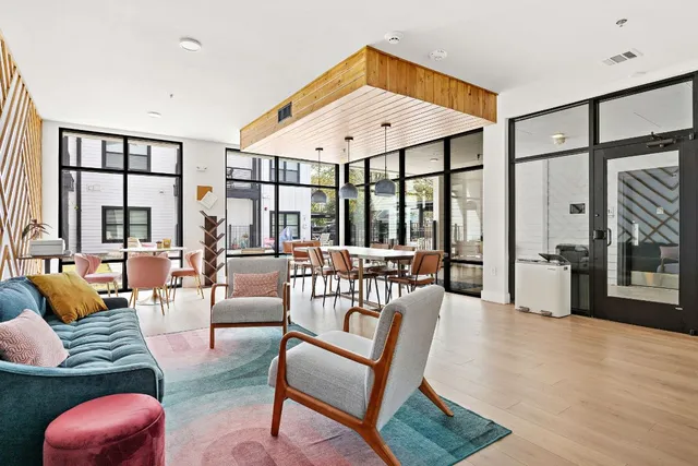 a living room with furniture a ceiling fan and a large window