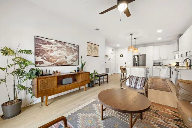 a living room with furniture and a painting on the wall