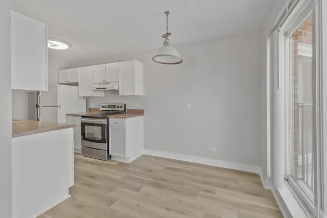 a kitchen with kitchen island white cabinets and stainless steel appliances
