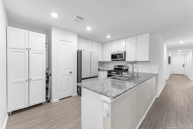 a kitchen with stainless steel appliances granite countertop a refrigerator stove microwave and sink