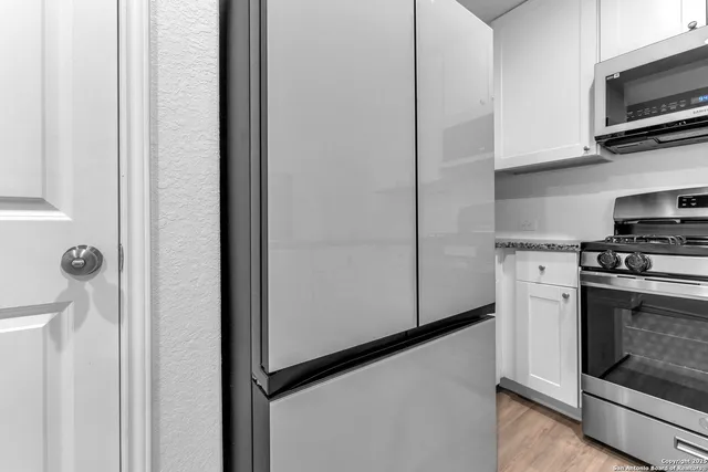 a kitchen with stainless steel appliances granite countertop a stove and a microwave