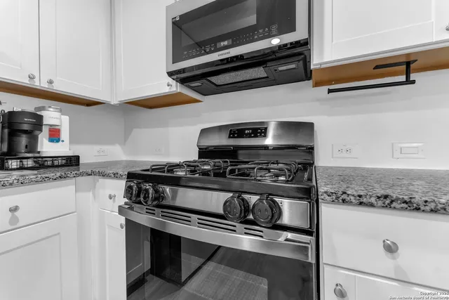 a kitchen with kitchen island a stove top oven a sink a dining table and chairs